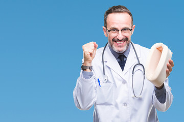 Middle age senior hoary doctor man holding neck collar over isolated background screaming proud and celebrating victory and success very excited, cheering emotion