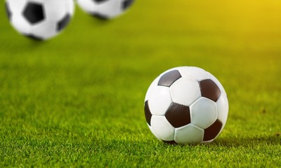Fototapeta premium Close view of green football field with soccer ball