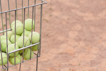 Tennis balls in the basket on the background of the tennis court