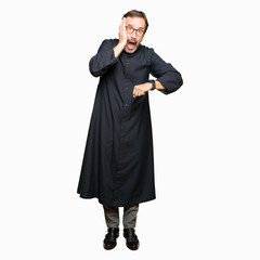 Middle age priest man wearing catholic robe Looking at the watch time worried, afraid of getting...
