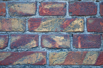 A wall of old, damaged red brick. Scratches and cracks. The background and texture of an antique retro brick.