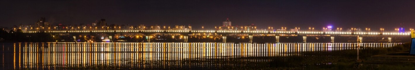 Fototapeta na wymiar Night panorama of the Paton bridge across the Dnipro in Kyiv