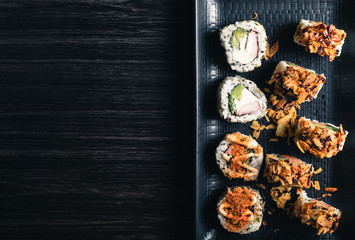 close up of sushi rolls on black tray. Copy space