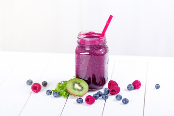 Smoothie in glass jar with fresh vibrant berries and fruits