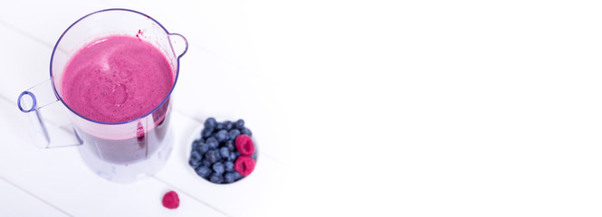 Fresh blended smoothie in blender cup with forest berries