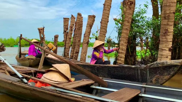 Wide shots of women on roaring boat into Mekong Delta River