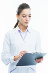 Young woman medic doctor practitioner with a folder in white uniform looking with a smile. 