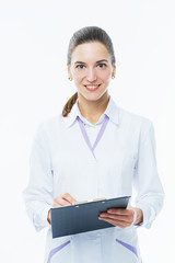 Young woman medic doctor practitioner with a folder in white uniform looking with a smile. 