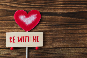 red heart on wooden background. Valentine's Day. celebration. the inscription on the plate "be with me"