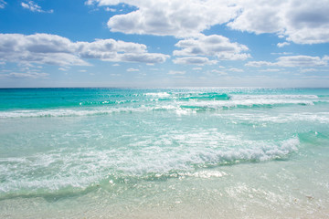 Fototapeta na wymiar Waves on Caribbean sea. Crystal clear water, Playa Delfines, Cancun, Mexico