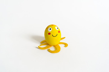 Easter holiday concept with cute handmade eggs: sea animal yellow octopus.