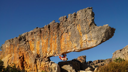 Rock climber on the Rhino boulder in Rocklands near Cape Town, South Africa.