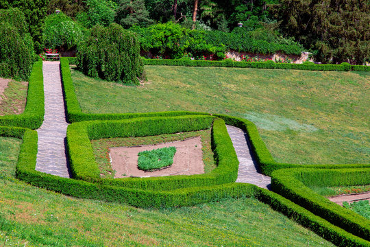 Stone Walkway With Hedge View From Above On A Maze Of Evergreen Bushes With A Glade Of Green Grass.