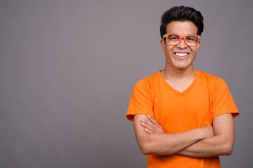 Portrait of young Asian man against gray background