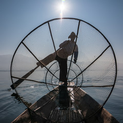 Burmese fisherman catching fish in traditional way. Inle lake, Myanmar