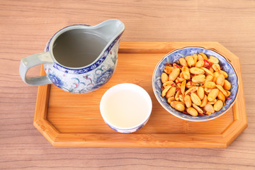 Spicy coated peanuts with tea on the table    