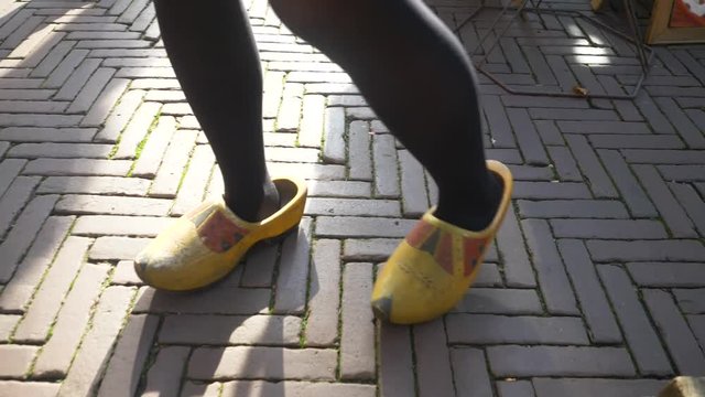 Feet of a girl trying on "klompen" or clogs, traditional wooden shoes, clothes in the Netherlands, Holland. At a market in Amsterdam.