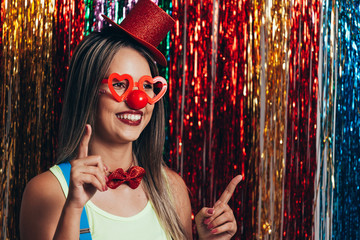 A female clown with colorful clothes and makeup on colorful background