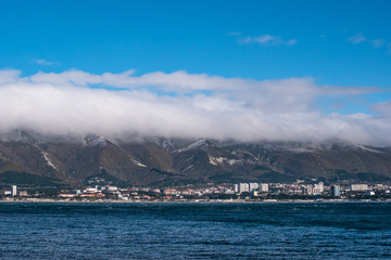 Fototapeta na wymiar Low lying clouds on mountains and sea on foreground, resort coastline