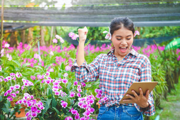 Flower farm woman Hold the tablet, lift the arms, rejoice Get orders from customers