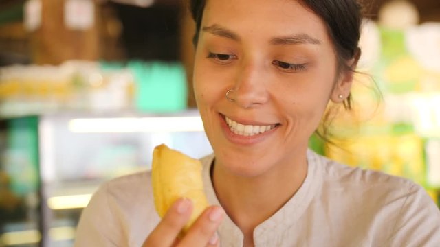 Young Tourist Woman Trying Durian First Time. Female Holding Piece of Durian Pulp and Sniffing It Enjoying Good Sweet Smell. 4K Slowmotion. Kuala Lumpur, Malaysia.