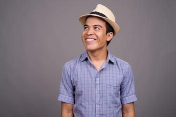 Young Asian tourist man ready for vacation against gray backgrou