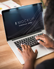 Woman working on a laptop screen mockup
