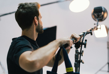 Young man adjusting the light in a studio