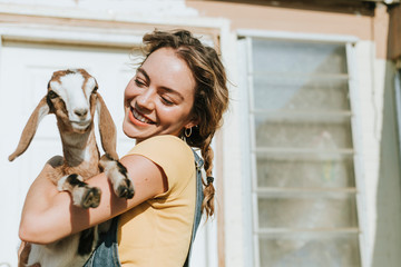 Portrait of a beautiful young woman with a goat