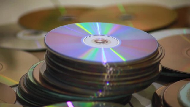 Dolly shot of a closeup of piles of old compact discs