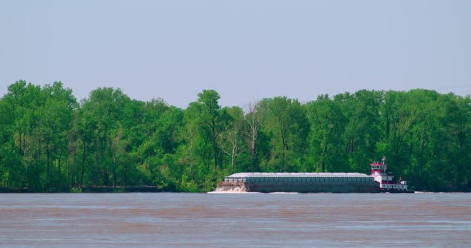 River boat pushing barges upstream on the Mississippi river