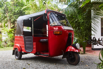 Red Tuk-tuk taxi on road of Sri Lanka. Ceylon travel car. 
