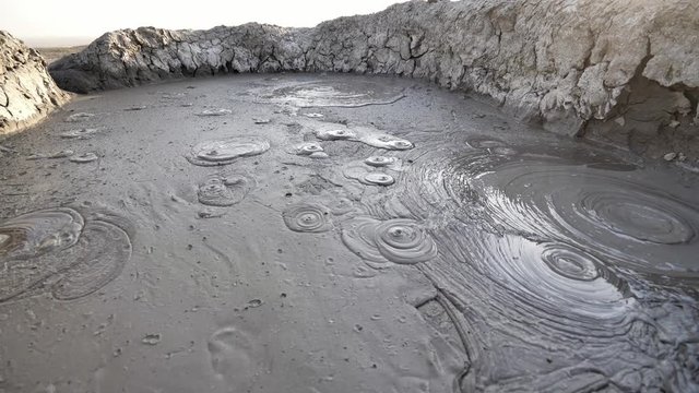 Wide angle view of mud bubbling in a large pool at the Mud Volcanoes in Baku, Azerbaijan