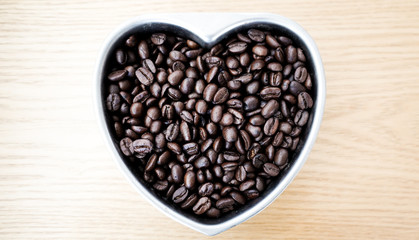 Coffee beans in the form of heart on the wooden table