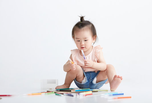 Asian little girl being painted, in white background