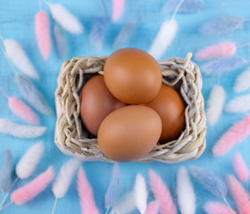 Easter eggs in basket decor on wooden background