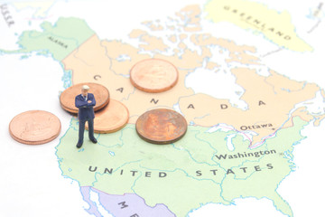 Miniature people, businessman standing on map American