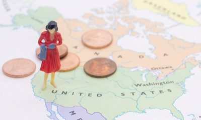 Miniature people, businesswoman standing on map American