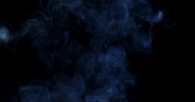 White cloud of smoke or vapor rising in slow motion against a black background