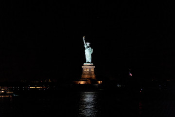 A view of Statue of Liberty at night from a ferry.