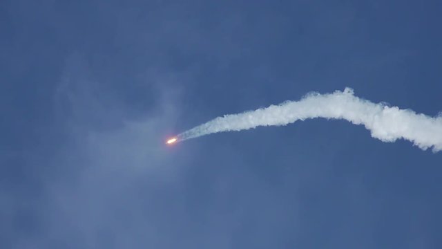 Rocket soars into space with bright trail of white smoke and exhaust.