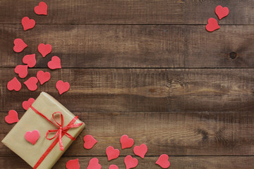 Gift box and red hearts on dark wooden boards. Valentines day concept. Border, copy space, wrapping, tag, discount