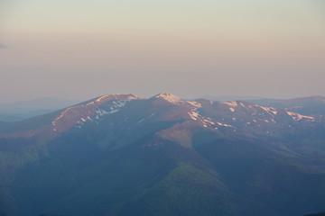 Summer in the Ukrainian Carpathians, overlooking the Chornohora mountain range with a thunder-storm rainbow.