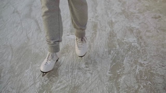 close-up legs in white skates glide over the ice. winter sports