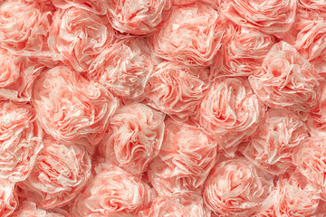 Decorative paper roses from napkins as texture background pattern. Creative festive wall decoration