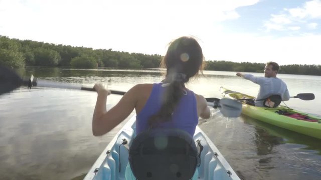 Couple kayaking together - Young couple on kayak travel adventure having fun kayaking in the ocean near Mangroves. From the Keys, Florida, USA