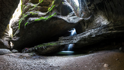 stone cave with a waterfall flowing inward. Salta Falls, Dagestan, Russia