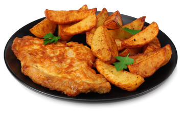 Fried potato wedges with schnitzel on black plate isolated on white background