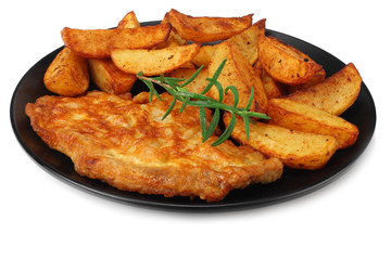 Fried potato wedges with schnitzel on black plate isolated on white background