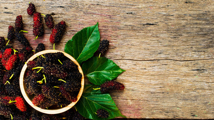 Mulberries fruits in wooden bowl on wood backgrounds above